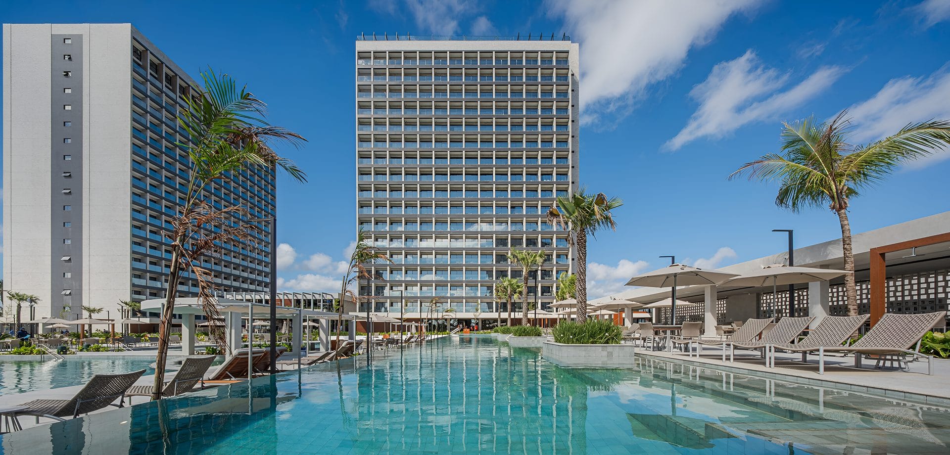 Área de piscina de resort com prédios ao fundo